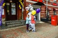 A man in zebra costume on a city street embraces and takes photos with passers-by. Advertising on the street. Work in advertising