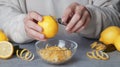 Man zesting lemon at grey table, closeup Royalty Free Stock Photo