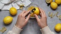 Man zesting lemon at grey table, closeup