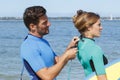 man zipping up womans wetsuit Royalty Free Stock Photo