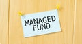 MANAGED FUND sign written on sticky note pinned on wooden wall Royalty Free Stock Photo