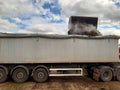 Management of biological waste from composting. The body of the trailer truck is filled with warm branches and grass, which releas