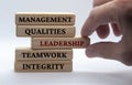 Management, qualities, leadership, teamwork and integrity text on wooden blocks with white background. Leadership