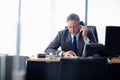 Management takes skill and patience. A senior businessman taking a call at his desk. Royalty Free Stock Photo