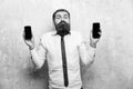 Manager or bearded man compare mobile phone and smartphone Royalty Free Stock Photo