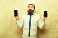 Manager or bearded man compare mobile phone and smartphone Royalty Free Stock Photo