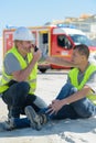 manager calling for help for construction worker injured at work Royalty Free Stock Photo