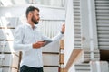 Manager checking the data by using tablet. Storage worker is in the warehouse with bunch of products Royalty Free Stock Photo