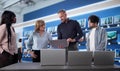Manager Comparing Laptops With Workers At Electronics Store Royalty Free Stock Photo