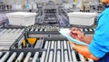 Manager engineer checking plastics boxes on conveyor belt in distribution warehouse Royalty Free Stock Photo