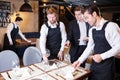 Manager explaining table setting to waiters Royalty Free Stock Photo