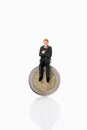 Manager figurine sitting on euro coin