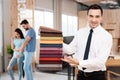 The manager of the furniture store holds samples of fabrics for furniture upholstery. Royalty Free Stock Photo