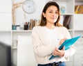 Manager girl is standing in the office and filling out documents on a folder Royalty Free Stock Photo