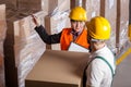 Manager giving worker instruction in warehouse