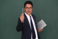 A manager in his smart suit holding laptop on left hand and pointing his pen on his right hand Royalty Free Stock Photo