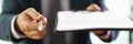 Manager holding out paper document on clipboard and pen for signing closeup Royalty Free Stock Photo