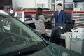 Manager and lady in cardealership shaking hands standing at table Royalty Free Stock Photo