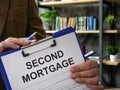 The manager offers a second mortgage documents to be signed.