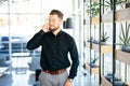 Young bearded business man in office talking at mobile phone in modern office Royalty Free Stock Photo