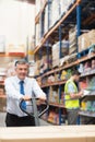 Manager pulling trolley with boxes in front of his employee Royalty Free Stock Photo