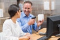 Manager scanning box while his colleague typing on laptop