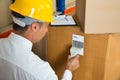 Manager Scanning Cardboard Box With Barcode Scanner