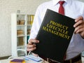 Manager shows Product Lifecycle Management PLM book. Royalty Free Stock Photo