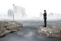 Manager standing on cliff with white flag and cloudy cityscape Royalty Free Stock Photo