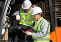 Manager talking with forklift operator