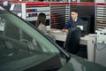Manager talking to lady in cardealership sitting at the table Royalty Free Stock Photo