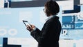 Manager using tablet to compare company metrics on digital videowall Royalty Free Stock Photo