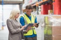 Manager using tablet while worker scanning package Royalty Free Stock Photo