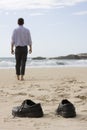 Manager walking barefoot on the beach