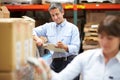 Manager In Warehouse With Worker Scanning Box In Foreground Royalty Free Stock Photo