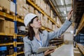 Manager woman in suit controlling goods in a waehouse. Royalty Free Stock Photo
