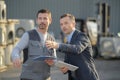 Manager with worker discussing over clipboard in industry Royalty Free Stock Photo