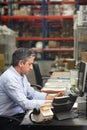 Manager Working At Desk In Warehouse