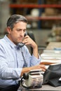 Manager Working At Desk In Warehouse