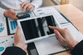 Managers are using tablets to analyze sales cost reports and explain summary reports to employees calculate and record summary Royalty Free Stock Photo