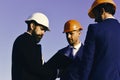 Managers wear smart suits, ties and hardhats on blue sky background. Constructors hold clip folder. Building and