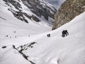 Manali, India - June 14th 2019: Bunch of people in a hiking group climbing on a slippery, steep glacial valley to reach Indian Him