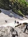 Manali, India - June 15th 2019: A group of hikers climbing down a glacial valley of Indian Himalayan Mountains by sliding down the