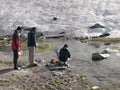 Manali, India - June 13th 2019: Hikers washing utensils with cold glacial water stream Royalty Free Stock Photo