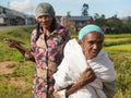 Manandoana, Madagascar - April 26, 2019: Unknown senior Malagasy women standing next to rice field where they worked on sunny day