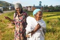 Manandoana, Madagascar - April 26, 2019: Unknown senior Malagasy women standing next to rice field where they worked on sunny day