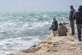 Manavgat, Turkey, 03.16.2021 - Turkish men fishermen stand on the stone coast and fish with fishing rods in the sea