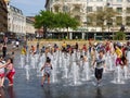 Children playing at Piccadilly Gardens water fountains on a hotday in Manchester city center