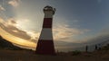 Tourists next to the Mancora lighthouse over the mountain on a cloudy sunset