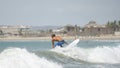 Young man on surfboard sliding on the waves on a clear day